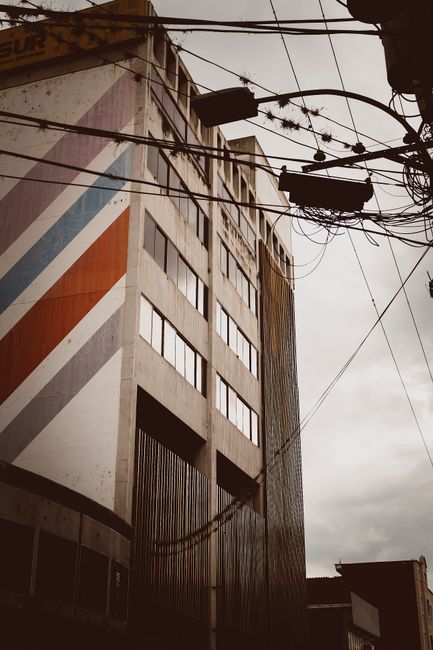 A modern urban building with colorful geometric design and power lines in Mérida, Venezuela.